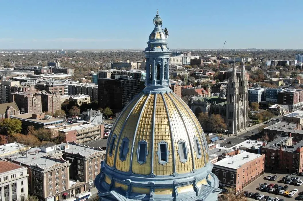 Gold domed civic building above a city skyline