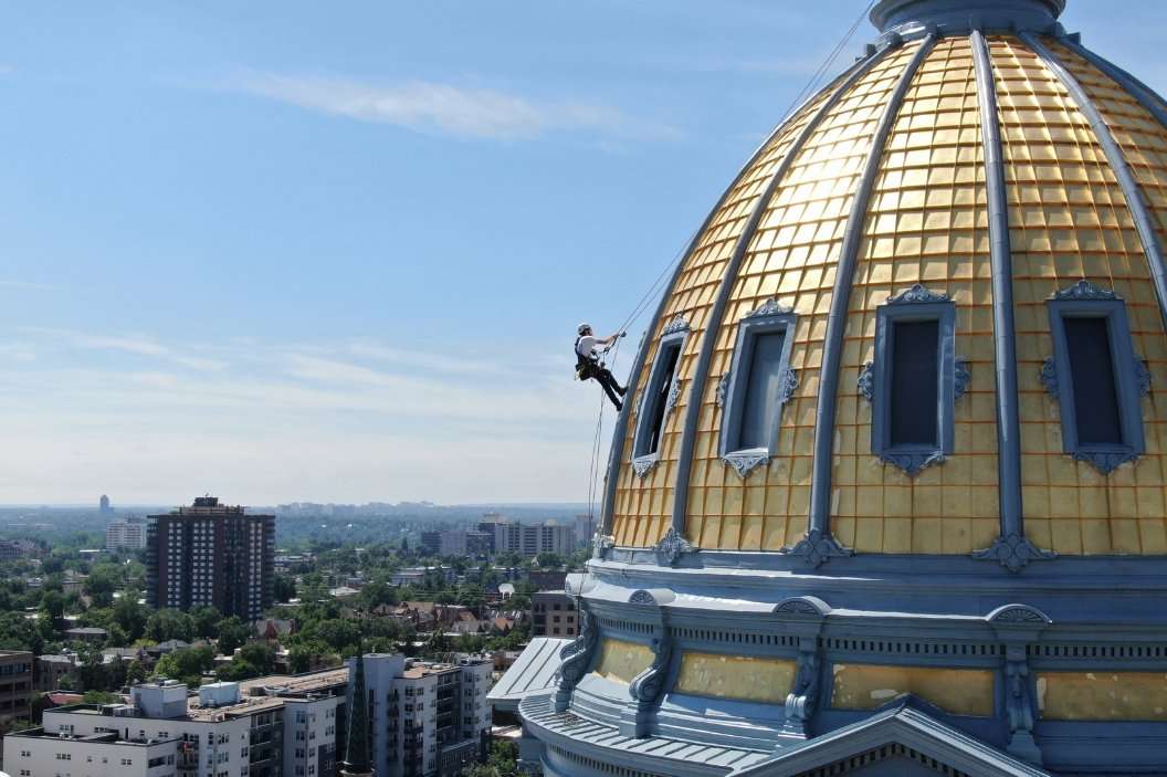 Painters working on a gold glass high-rise tower