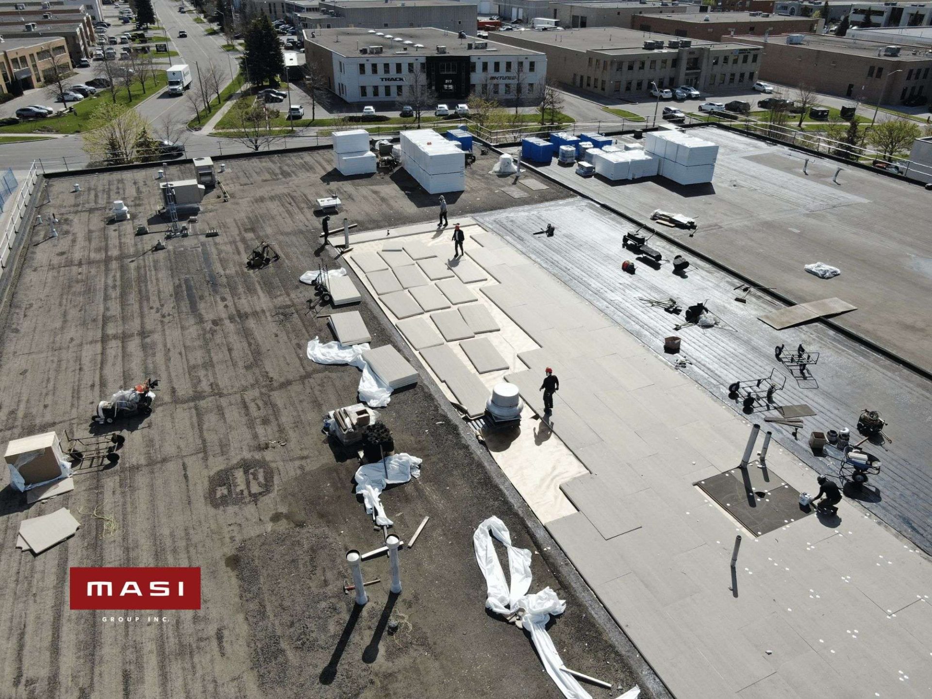 Roofing materials staged across a large commercial roof