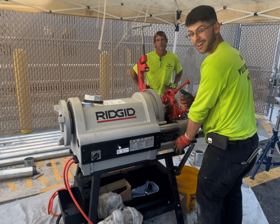 Plumbers installing equipment outdoors