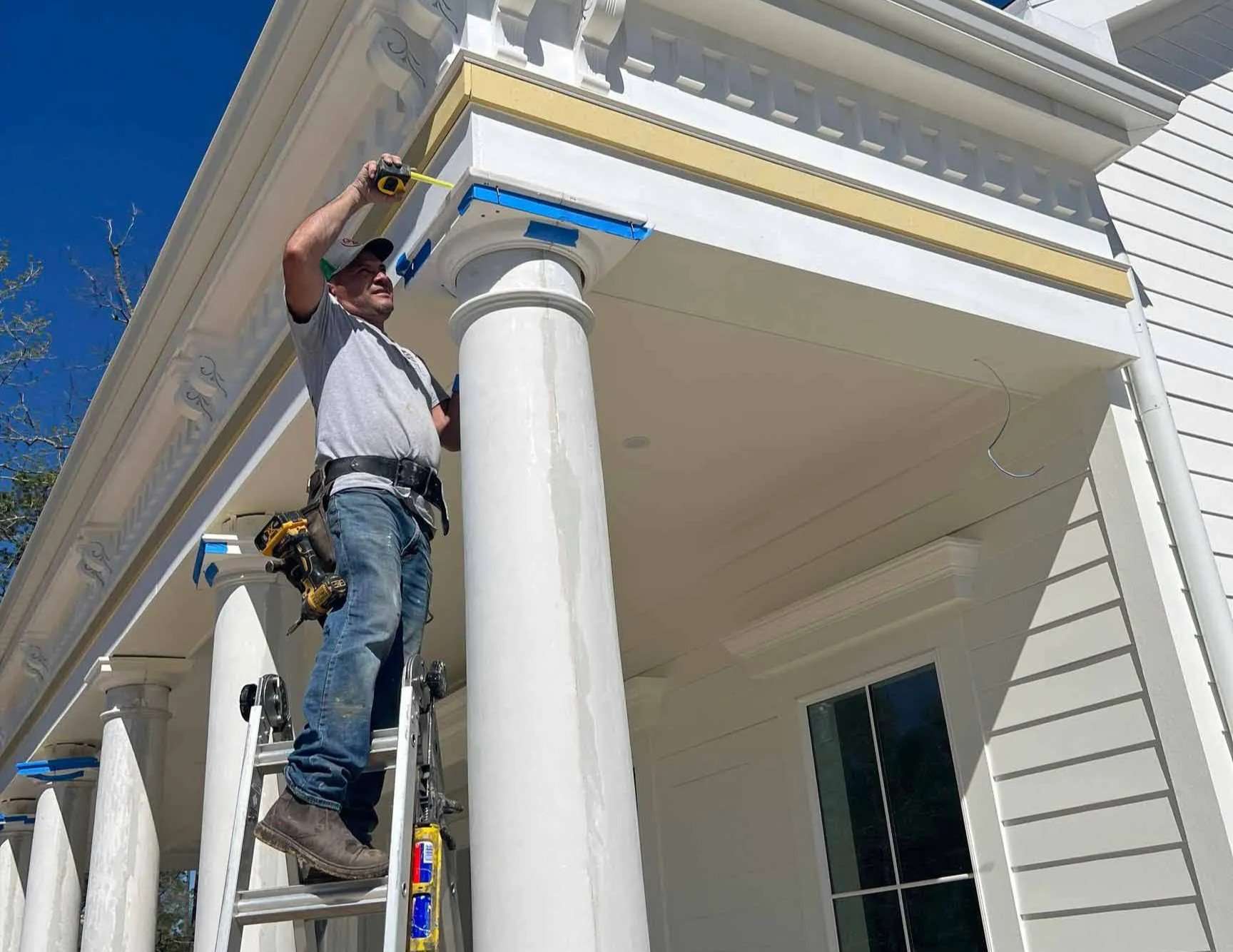Worker on a ladder finishing an exterior column