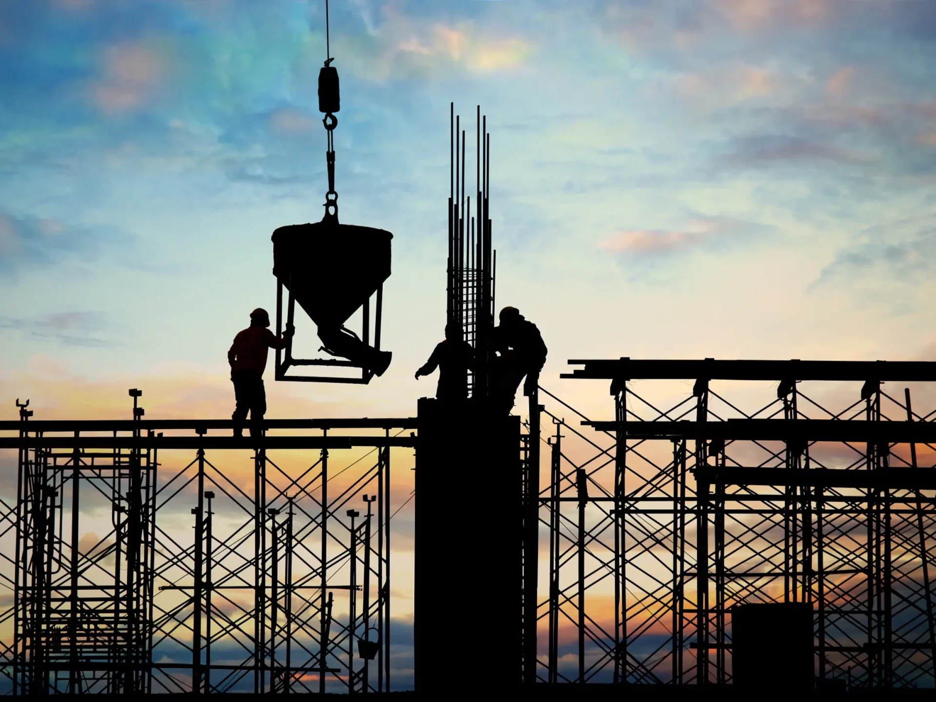 Rebar and formwork silhouetted against an evening sky