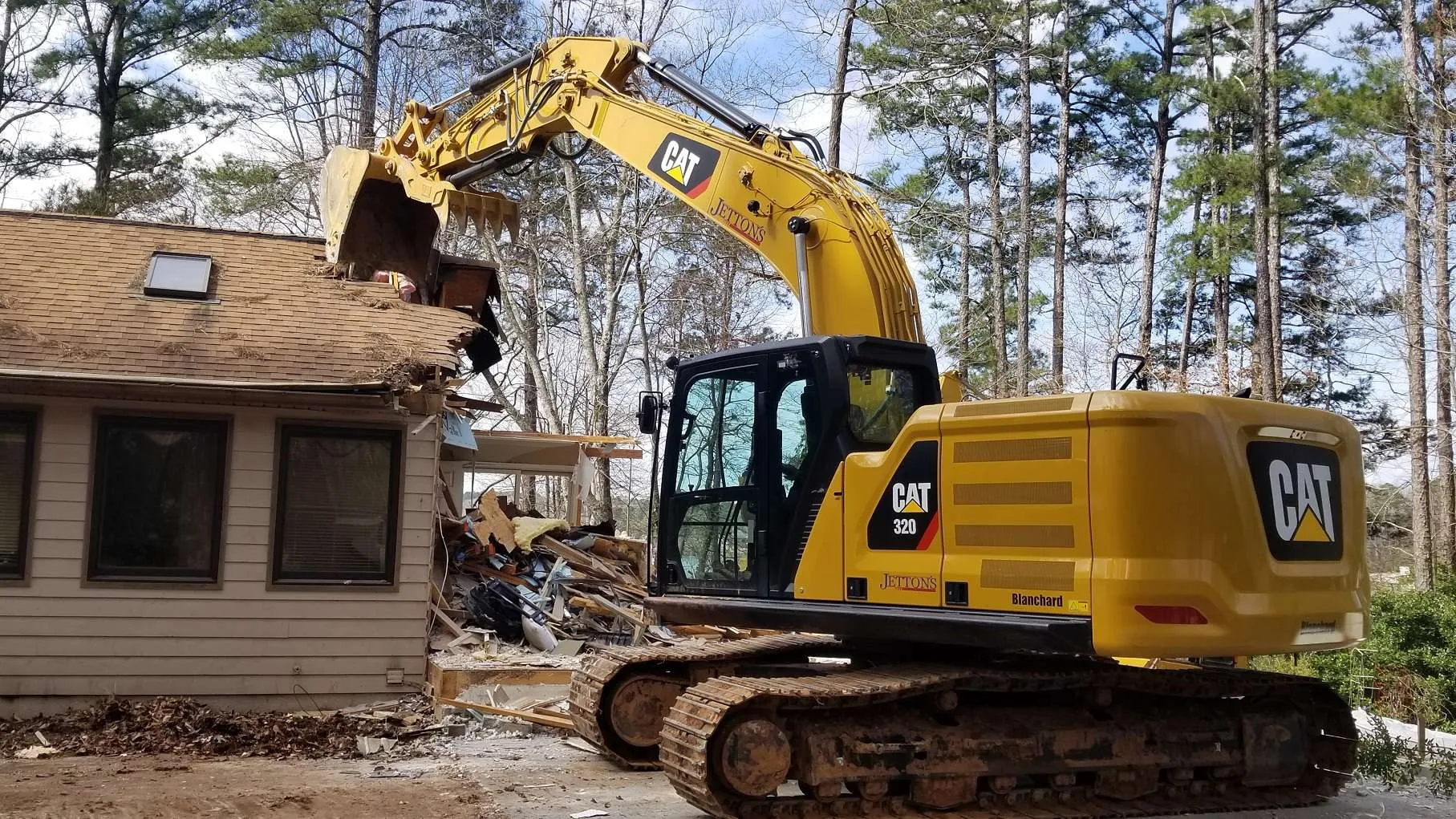 Excavator demolishing a residential property
