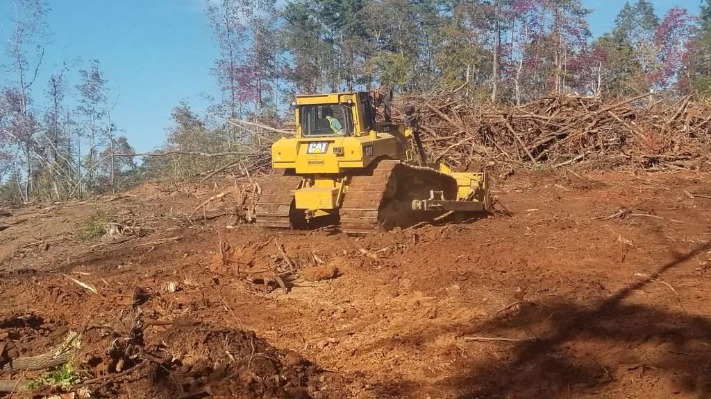 Bulldozer grading red clay soil