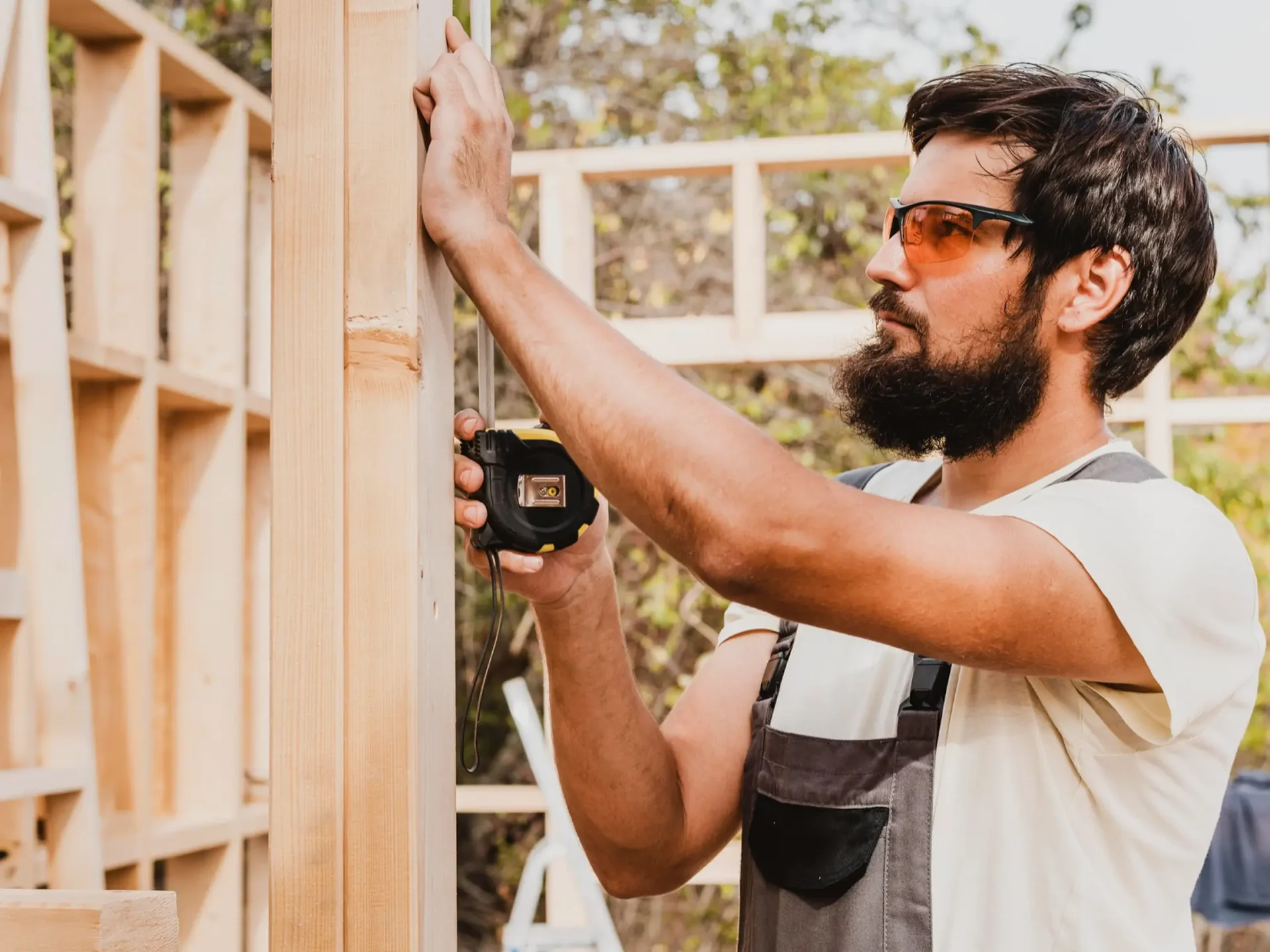 Carpenter using a drill on timber framing