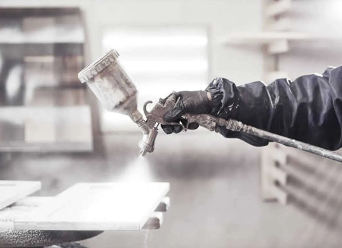 Close-up of a gloved worker applying a protective coating