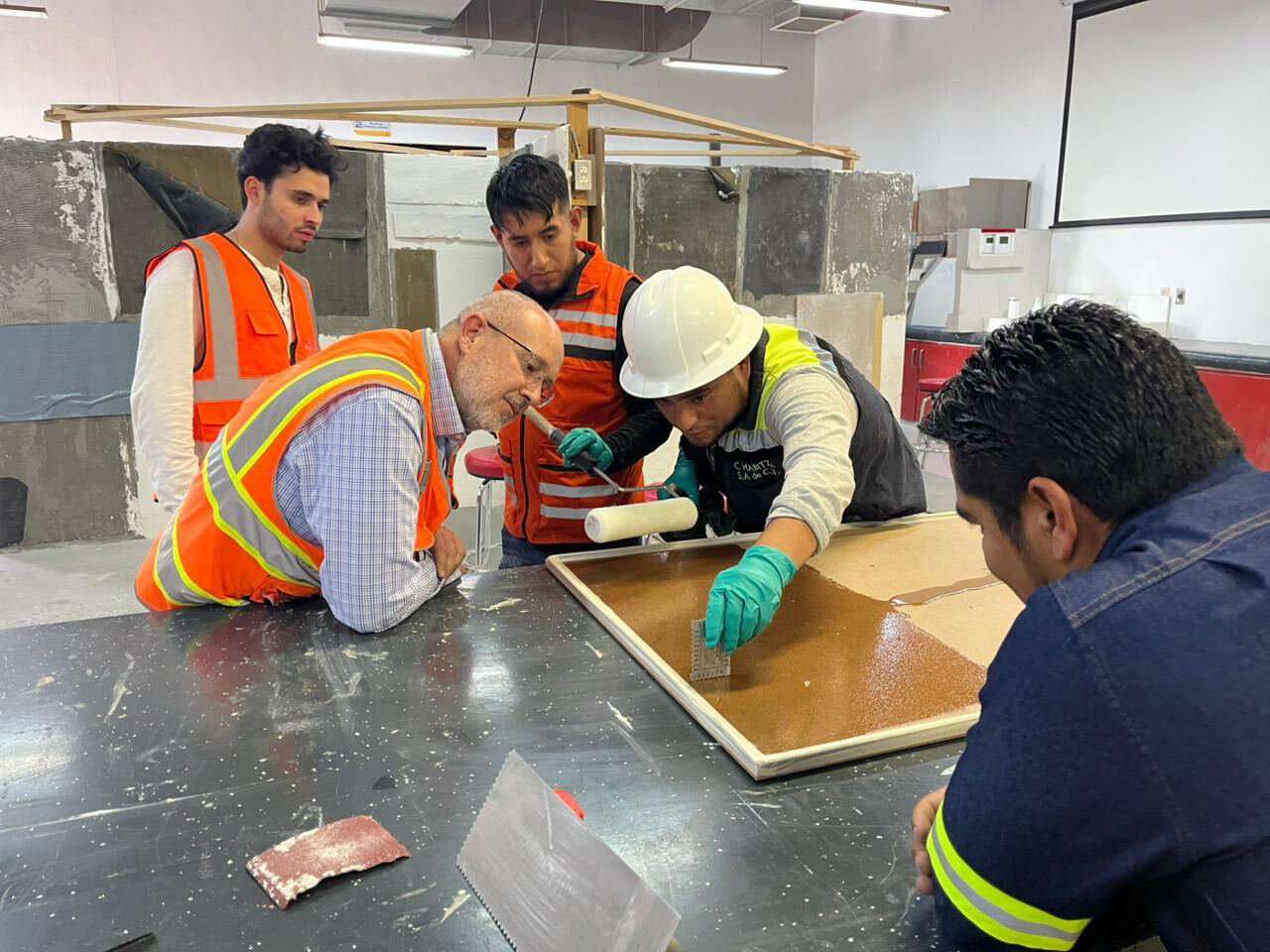 Crew applying an epoxy floor coating indoors
