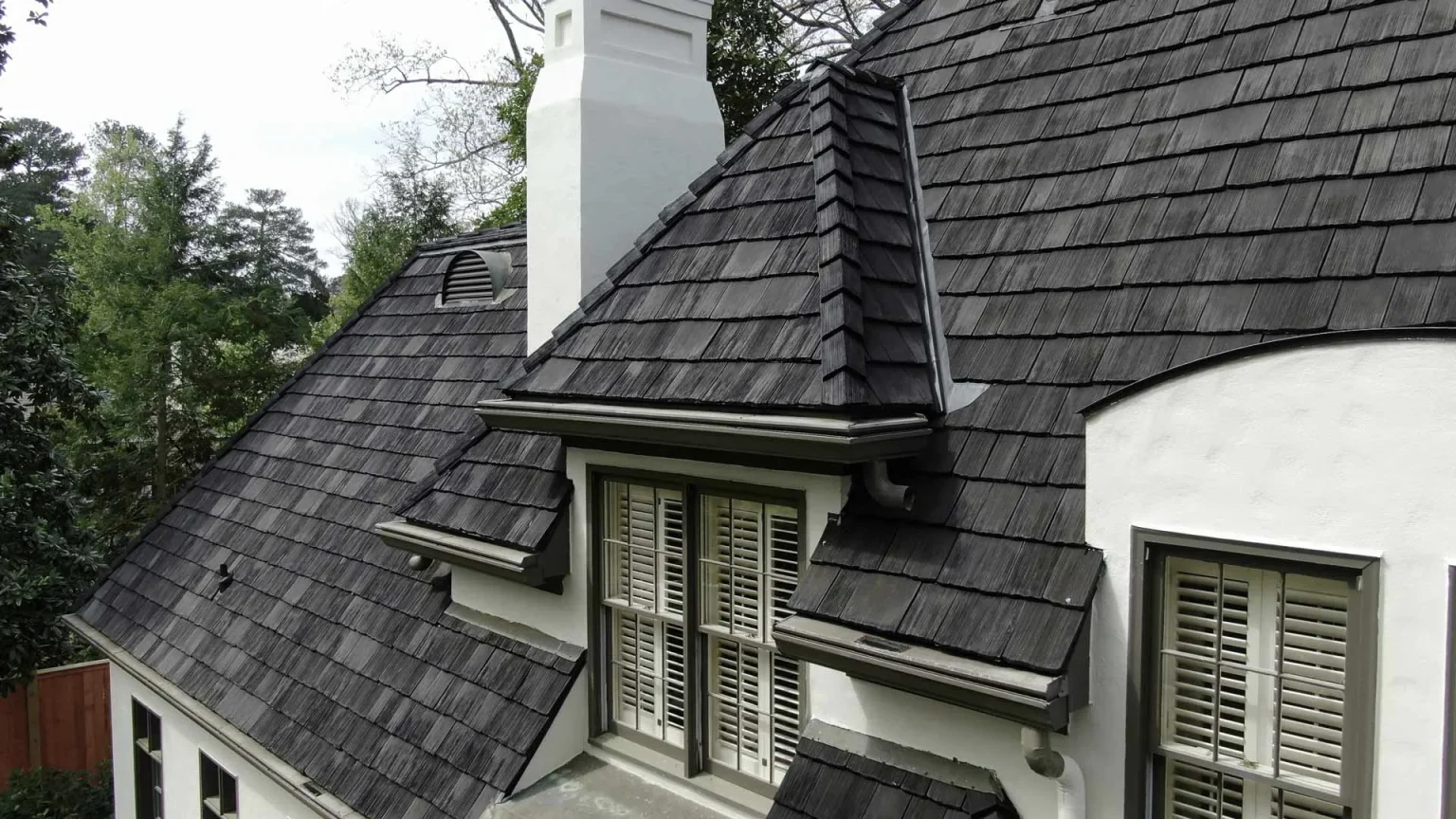 Close-up of a shingled roof and dormer window